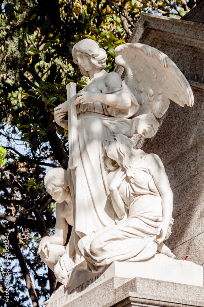 Obraz premium Sculpture of an angel caring for a grave in the Recoleta cemetery in Buenos Aires