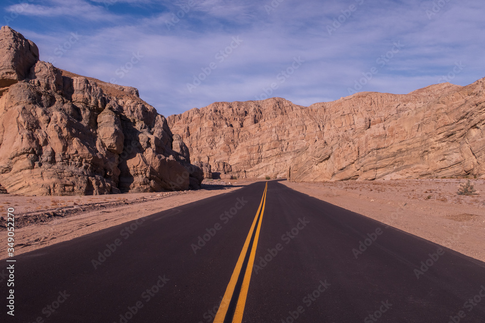 Landscape of road in the desert leading to barren hills Landscape of road in the desert leading to barren hills