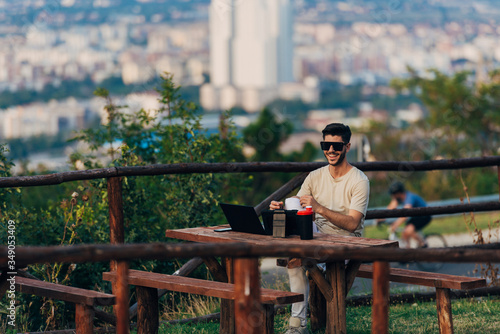 Young freelancer work on laptop against city background