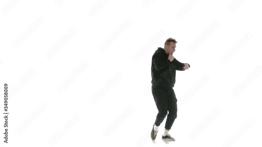 young handsome man in black tracksuit vigorously dancing hip hop, freestyle, street dance, performs complex movements, isolated, slow motion young handsome man in black tracksuit vigorously dancing hip hop, freestyle, street dance, performs complex movements, isolated, slow motion