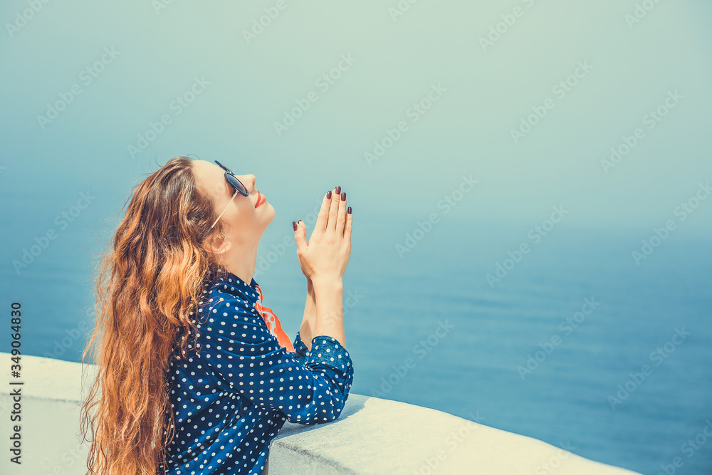 Young woman praying looking up to the sky