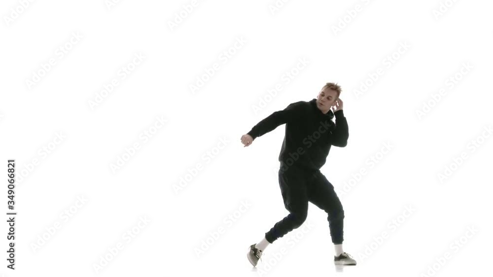 young handsome guy in black tracksuit vigorously dancing hip hop, freestyle, street dance, performs complex movements, isolated, slow motion young handsome guy in black tracksuit vigorously dancing hip hop, freestyle, street dance, performs complex movements, isolated, slow motion