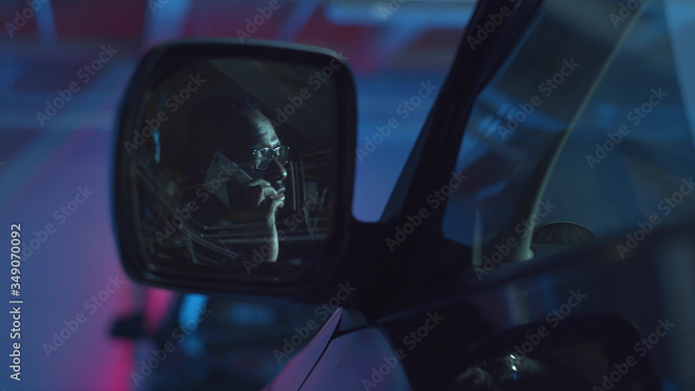 A man is talking on the phone. Car side view mirror A man is talking on the phone. Car side view mirror