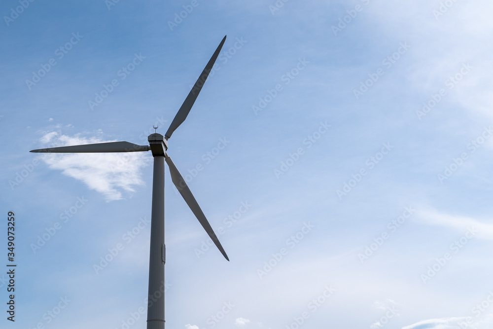 Wind turbine in Maple Grove, Minnesota, against a blue sky with clouds in a park Wind turbine in Maple Grove, Minnesota, against a blue sky with clouds in a park