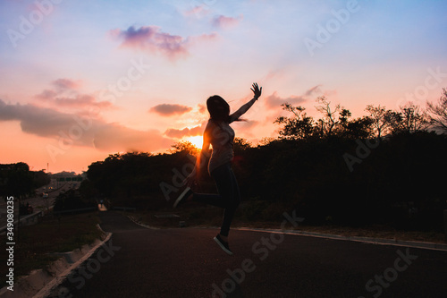 silhouette of a woman jumping on sunset