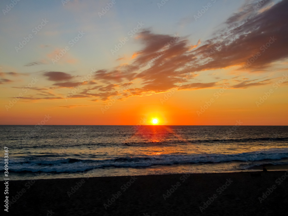 Sunset at sea in a stunning sunset with dramatic sky formed by the reflection of the sun in the clouds, in Mazatlan Mexico