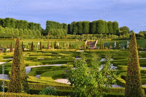 A fragment of the picturesque landscape of the park with green spaces, paths and artificial ponds near the Swedish castle Frederiksborg on a sunny day