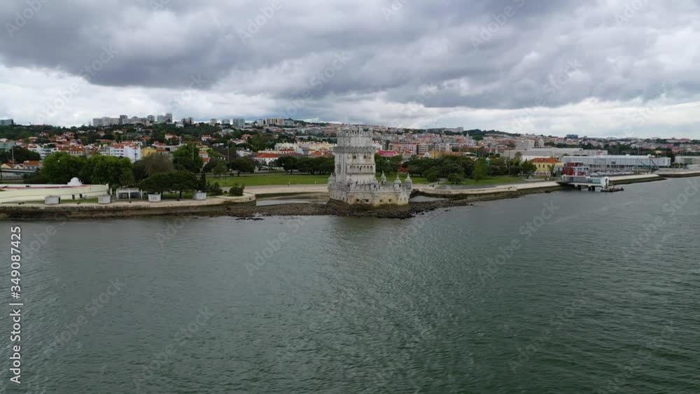 Aerial, orbit, drone shot over a boat at the tagus river, around theTorre de Belem tower, cloudy day, in Lisbon, Portugal Aerial, orbit, drone shot over a boat at the tagus river, around theTorre de Belem tower, cloudy day, in Lisbon, Portugal