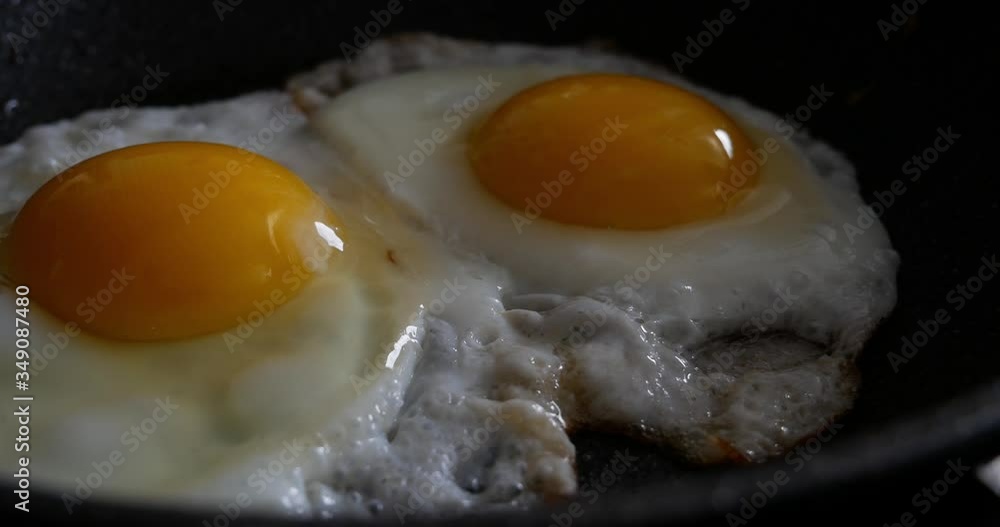 Freshly Cracked Eggs Sizzling in a Hot Frying Pan for Breakfast Freshly Cracked Eggs Sizzling in a Hot Frying Pan for Breakfast