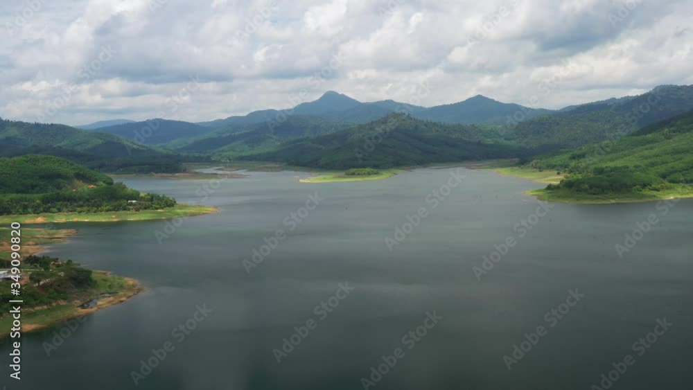 Aerial view of the river in the dam in the south of Thailand, Flying over the Dam on the river, Green fields and forests. Summer, cloudy sky. Aerial filming. Aerial view of the river in the dam in the south of Thailand, Flying over the Dam on the river, Green fields and forests. Summer, cloudy sky. Aerial filming.