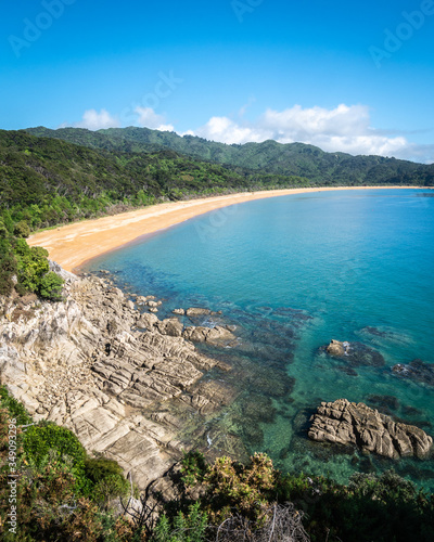 View on the tropical beach with golden sands and azure waters. Portrait shot made in Abel Tasman National Park, New Zealand photo