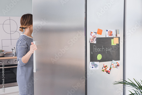 Young woman opening refrige...