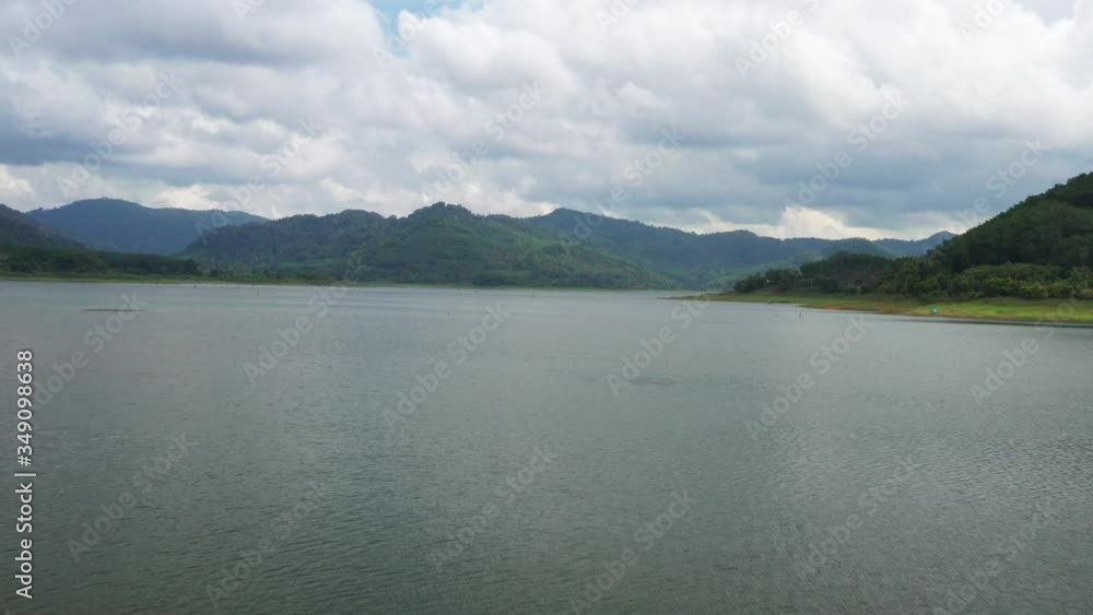 Aerial view of the river in the dam in the south of Thailand, Flying over the Dam on the river, Green fields and forests. Summer, cloudy sky. Aerial filming. Aerial view of the river in the dam in the south of Thailand, Flying over the Dam on the river, Green fields and forests. Summer, cloudy sky. Aerial filming.