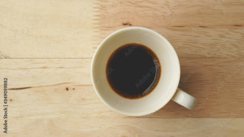 Stop motion drinking hot coffee on wooden table, Top view Stop motion drinking hot coffee on wooden table, Top view