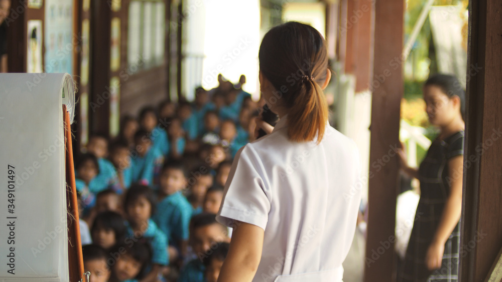 Blurred images of an Asian female doctor teaching a health education to school children. Blurred images of an Asian female doctor teaching a health education to school children.