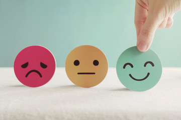 Hand choosing happy smile face paper cut, good feedback rating and positive customer review, mental health assessment, child wellness,world mental health day, think positive ethics concept