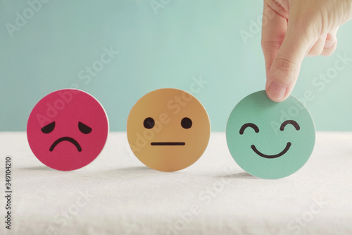 Hand choosing happy smile face paper cut, good feedback rating and positive customer review, mental health assessment, child wellness,world mental health day, think positive, compliment day concept photo