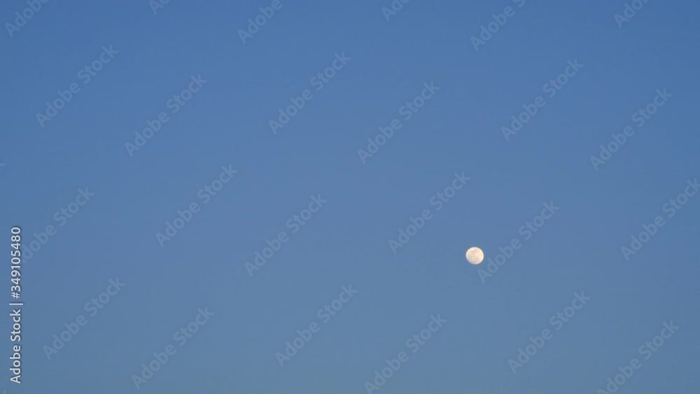 Abstract nature blurred background TimeLapse of wispy moon shining & rising on clear cloudless dark blue sky with no clouds at evening sunset before night scene, day to night concept, b-roll Abstract nature blurred background TimeLapse of wispy moon shining & rising on clear cloudless dark blue sky with no clouds at evening sunset before night scene, day to night concept, b-roll