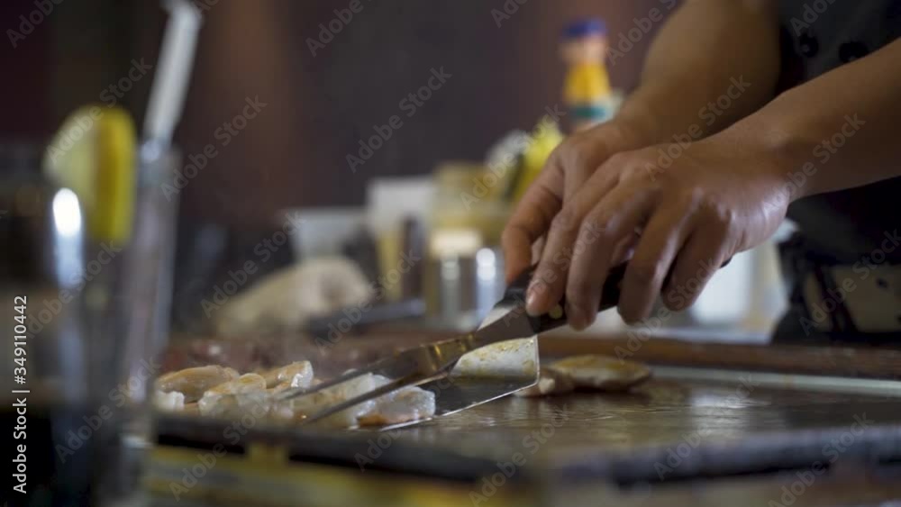 Flipping shrimps in a teppanyaki restaurant, close up of chef hands and food Flipping shrimps in a teppanyaki restaurant, close up of chef hands and food