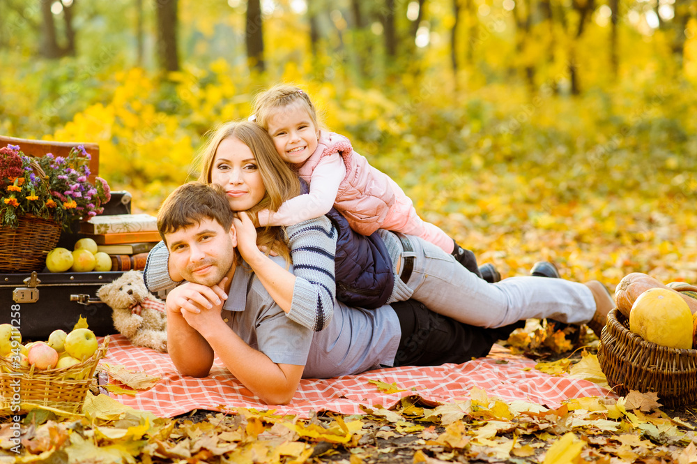 Dad, mom and daughter have fun together during an autumn picnic on the street. Dad, mom and daughter have fun together during an autumn picnic on the street.