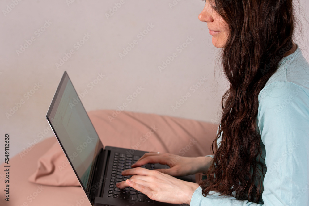 The concept of social distance and isolation. Work from home remotely over the Internet. A young woman works at home on a computer. Copy space. The concept of social distance and isolation. Work from home remotely over the Internet. A young woman works at home on a computer. Copy space.
