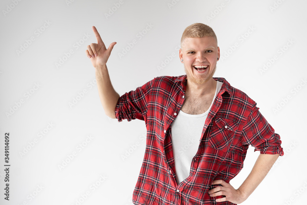 Surprised young man showing with index finger on empty copy space. A stunned, amazed, surprised man was standing, pointing to the side with his index finger Surprised young man showing with index finger on empty copy space. A stunned, amazed, surprised man was standing, pointing to the side with his index finger