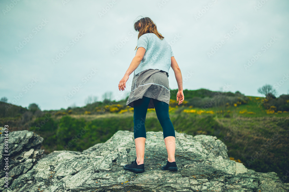 Young woman standing on rocks in the countryside