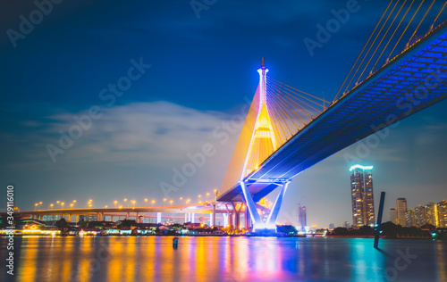 Bhumibol Bridge crossing the Chao Phraya River in Phra Pradaeng, Samut Prakan, Thailand at night. The most beautiful river bridge in Thailand. Cityscape of beautiful Bhumibol bridge.