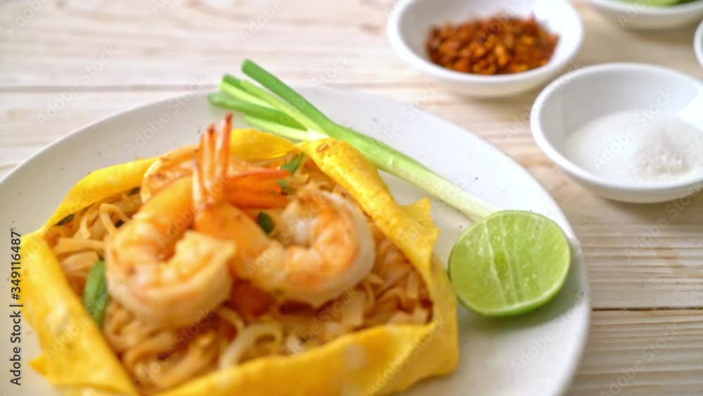 Thai stir fried noodles with shrimps and egg wrap (Pad Thai) - Thai food style Thai stir fried noodles with shrimps and egg wrap (Pad Thai) - Thai food style