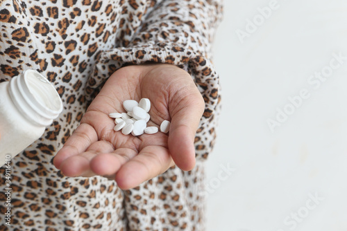 young woman pouring pills from bottle on hand with copy space 