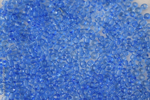 Blue beads scattered on a white background.