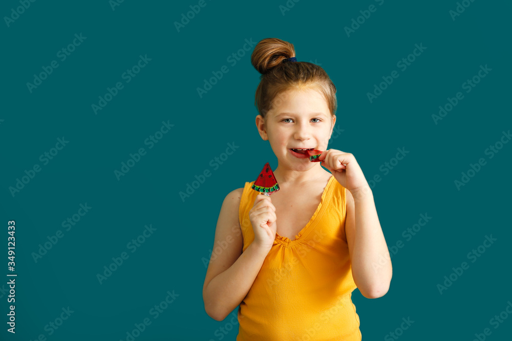 kid 7 years old with watermelon lollipop on green
