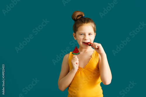 kid 7 years old with watermelon lollipop on green