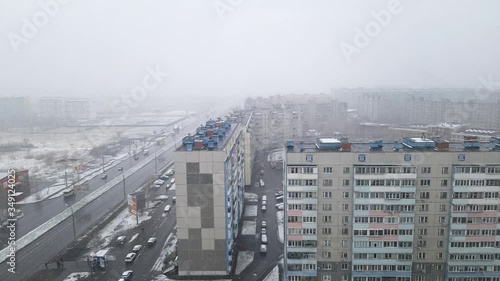 Timelapse street in city. View from window. Snowing. The flow of cars on the road