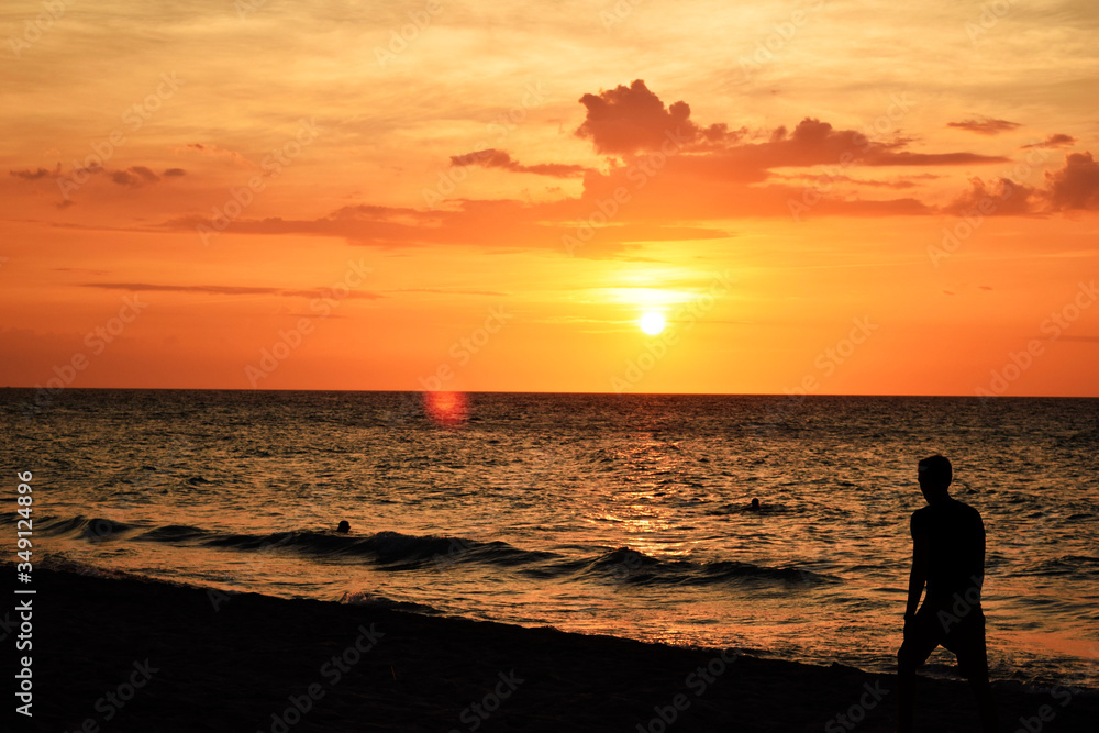 beautiful sunset on the ocean and people silhouettes