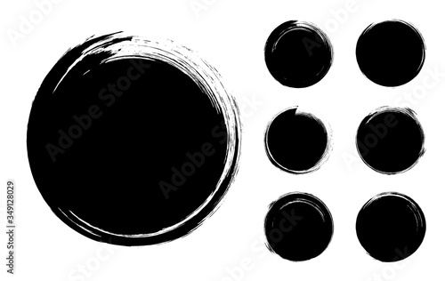 Collection of abstract brushed black ink circles with rough edges and grungy texture