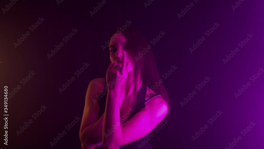 Beautiful young brunette girl in a nude outfit dancing in a studio with multi-colored light, background, slow motion Stock ビデオ | Adobe Stock