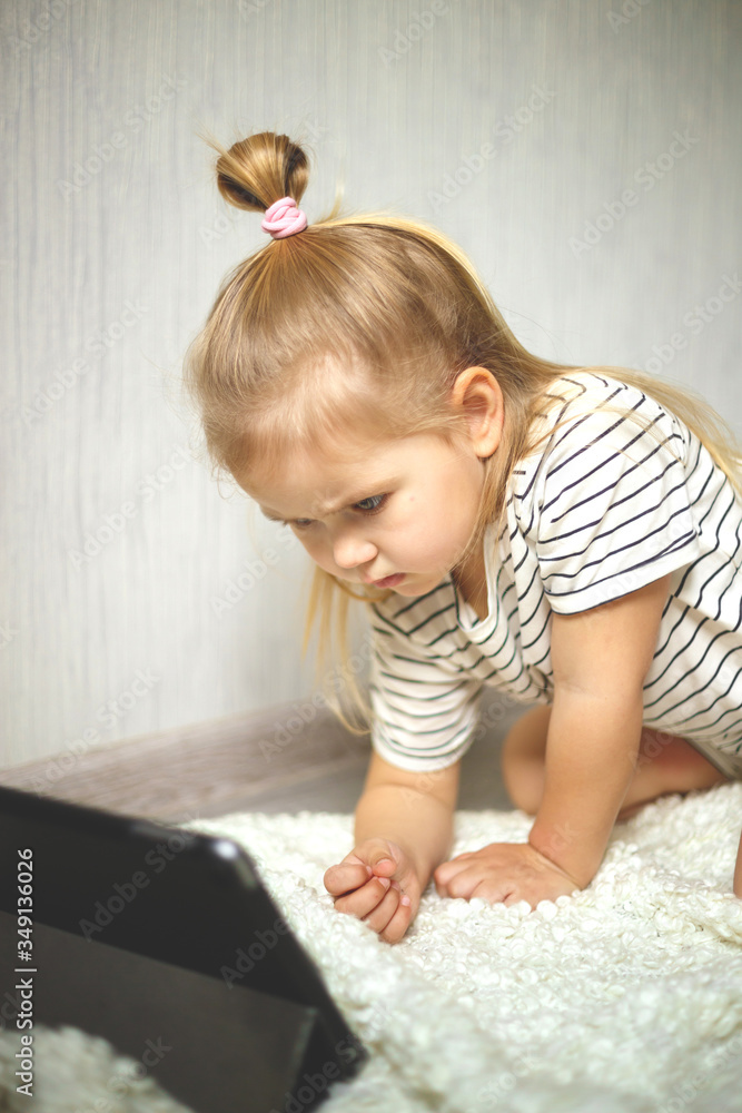 little girl at home watching tablet computer. home schooling, distance learning little girl at home watching tablet computer. home schooling, distance learning