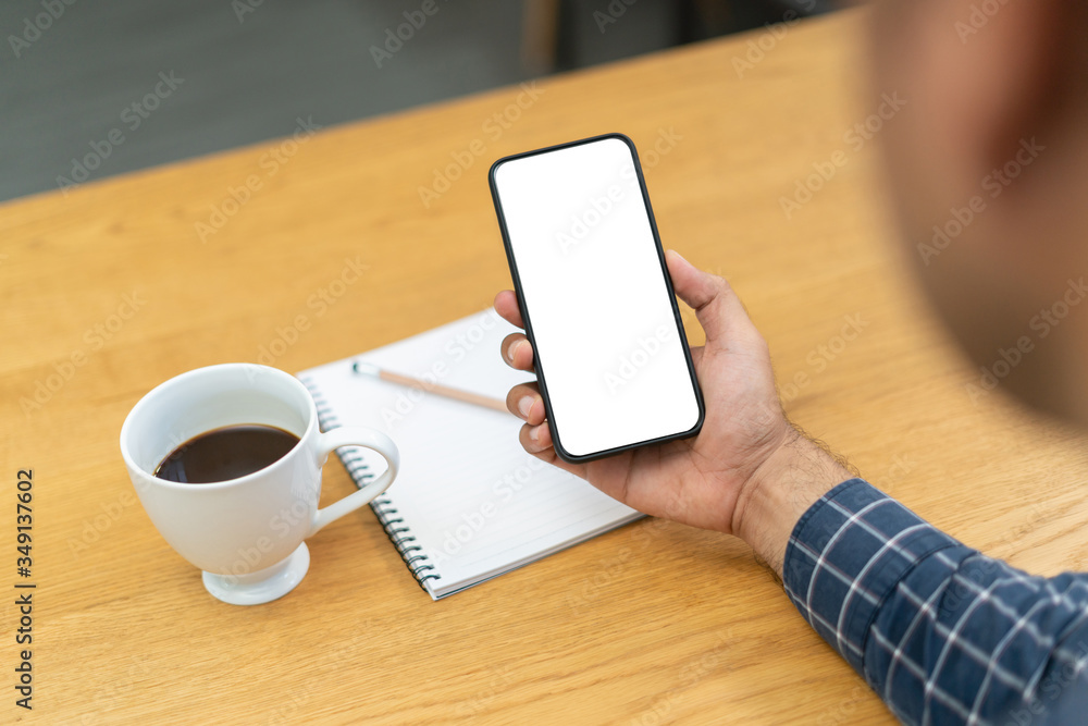 Young man drinking coffee and holding blank screen of smartphone in the morning. Young man drinking coffee and holding blank screen of smartphone in the morning.