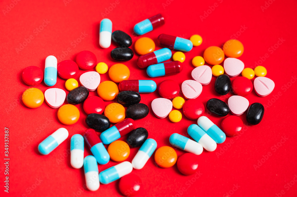 A lot of pill on the red background. Medicine pills, tablets and capsules. A lot of pill on the red background. Medicine pills, tablets and capsules.