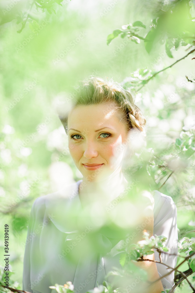 Calm portrait of a beautiful woman in apple blossom. Boho girl sensual portrait in modern floral dress in greenery. Place for text Calm portrait of a beautiful woman in apple blossom. Boho girl sensual portrait in modern floral dress in greenery. Place for text
