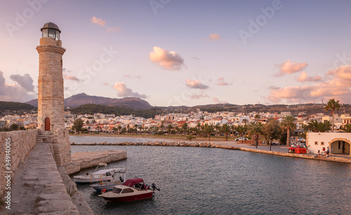 Lighthouse of Venetian Harbor at sunrise under colored clouds. Rethymno, Crete, Greece