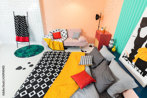 Living room interior in modern apartment with colorful furniture and textile, black and white printed details. 