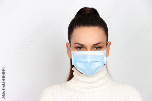 Obraz na płótnie Jeune femme brune portant un masque chirurgical pour se protéger des virus isolé