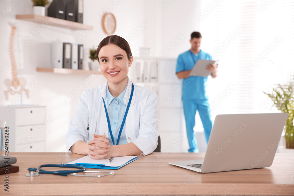 Portrait of female doctor at table in modern clinic Portrait of female doctor at table in modern clinic