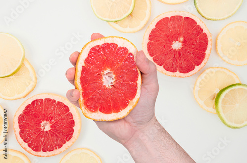 male squeezes in a hand grapefruit . flat lay orange grapefruit set composition