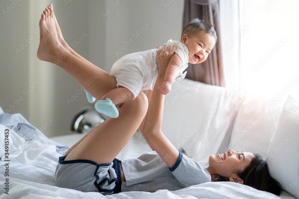 Fototapeta premium Asian Mother and child on a white bed