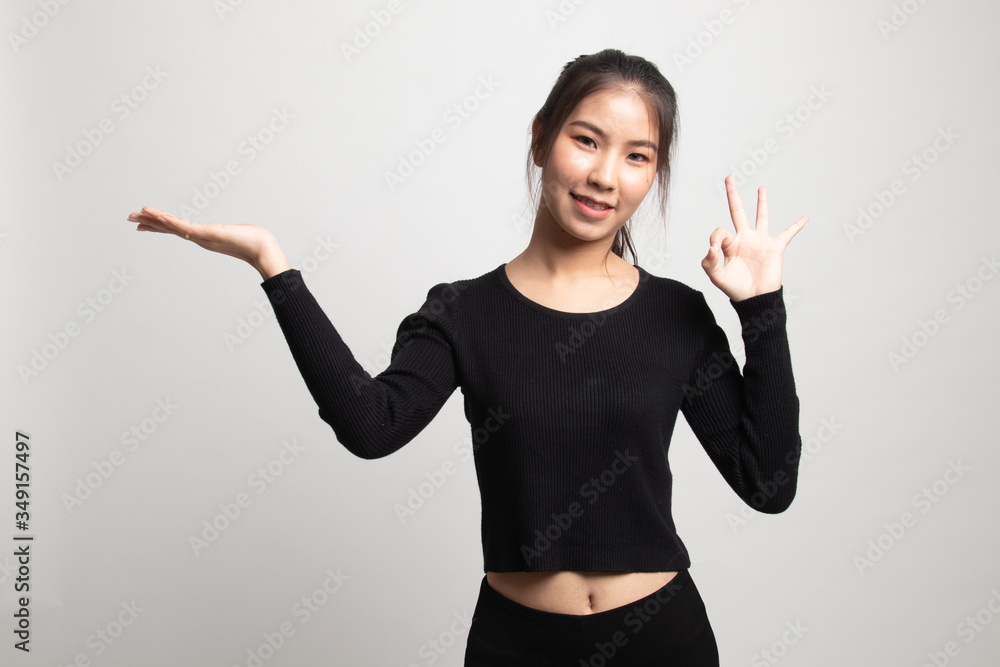 Beautiful young Asian woman show palm hand and OK sign. Beautiful young Asian woman show palm hand and OK sign.