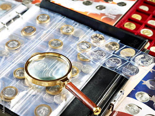 Fotografie Numismatic coins with magnifying glass