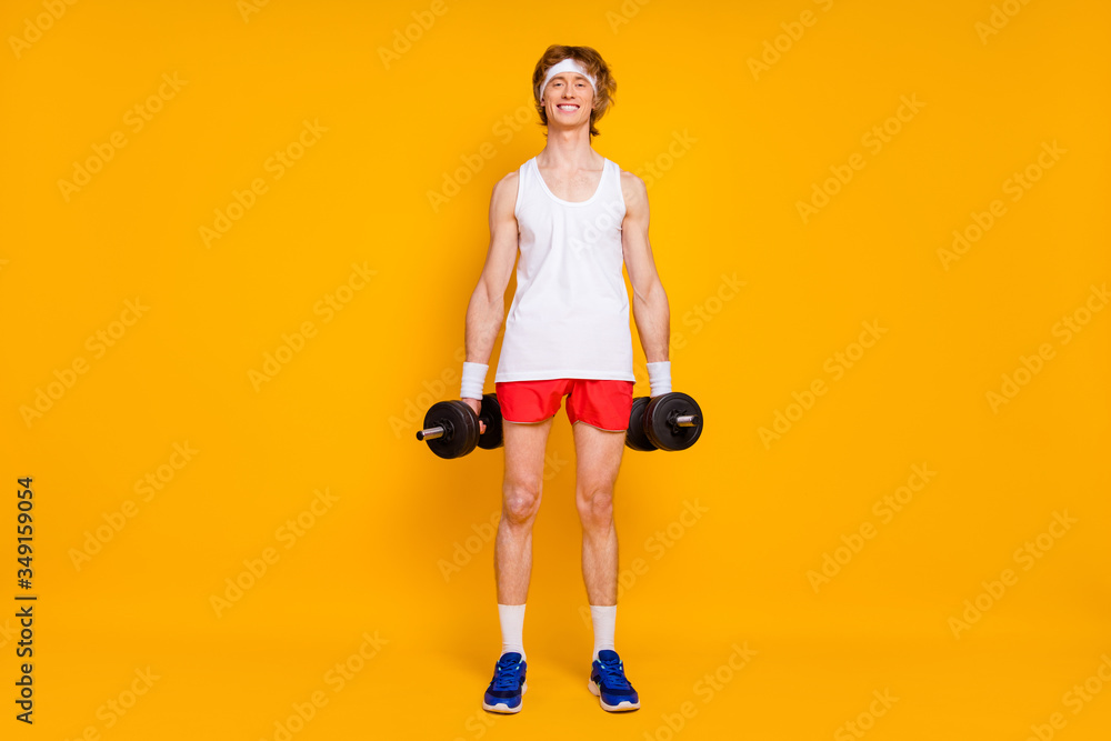 Full length body size view of his he nice attractive cheerful cheery slim thin guy sportsman doing work out holding in hand barbell isolated over bright vivid shine vibrant yellow color background Full length body size view of his he nice attractive cheerful cheery slim thin guy sportsman doing work out holding in hand barbell isolated over bright vivid shine vibrant yellow color background